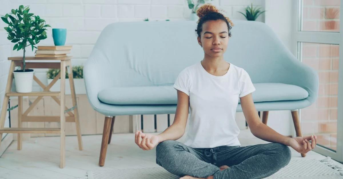 Une femme médite dans un salon serein avec une décoration moderne.